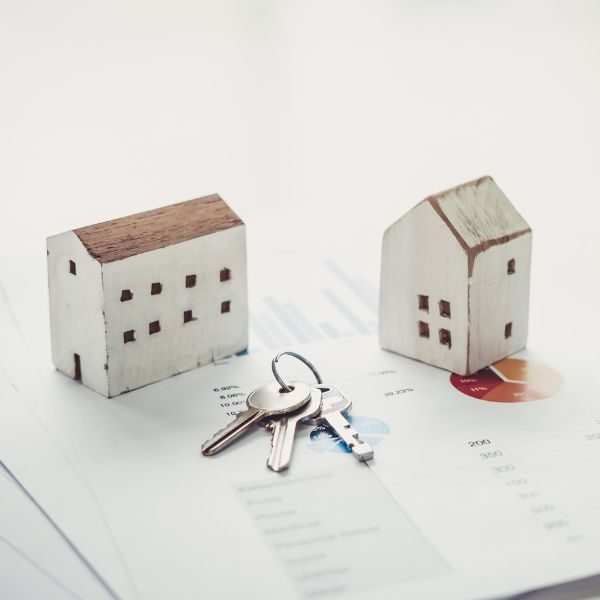 Två små hus och en nyckelknippa ligger uppe på ett gåvobrev