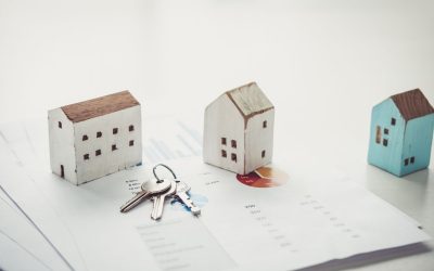 tre hus och en nyckelknippa ligger på bouppteckningshandlingar