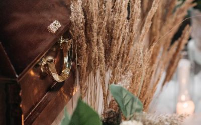 Bild på en kista med blomsterarrangemang bredvid